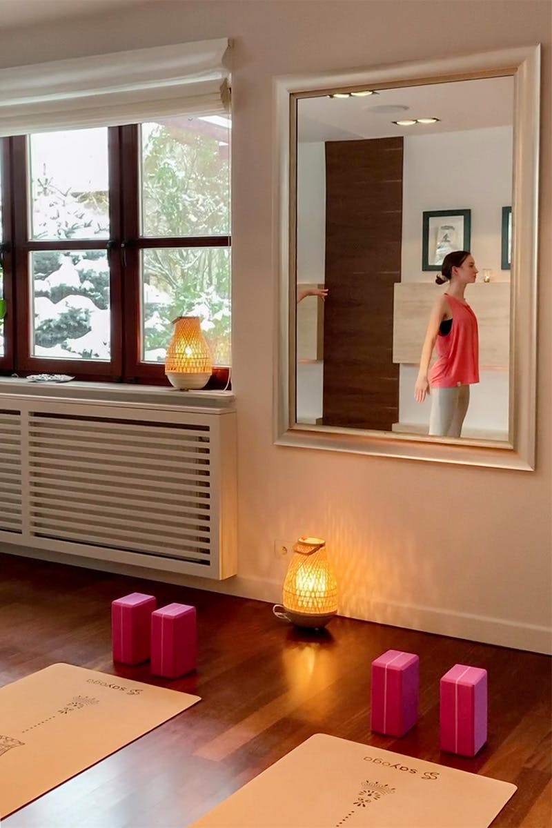 großer Spiegel an der Wand in einem kleinen Yoga-Studio