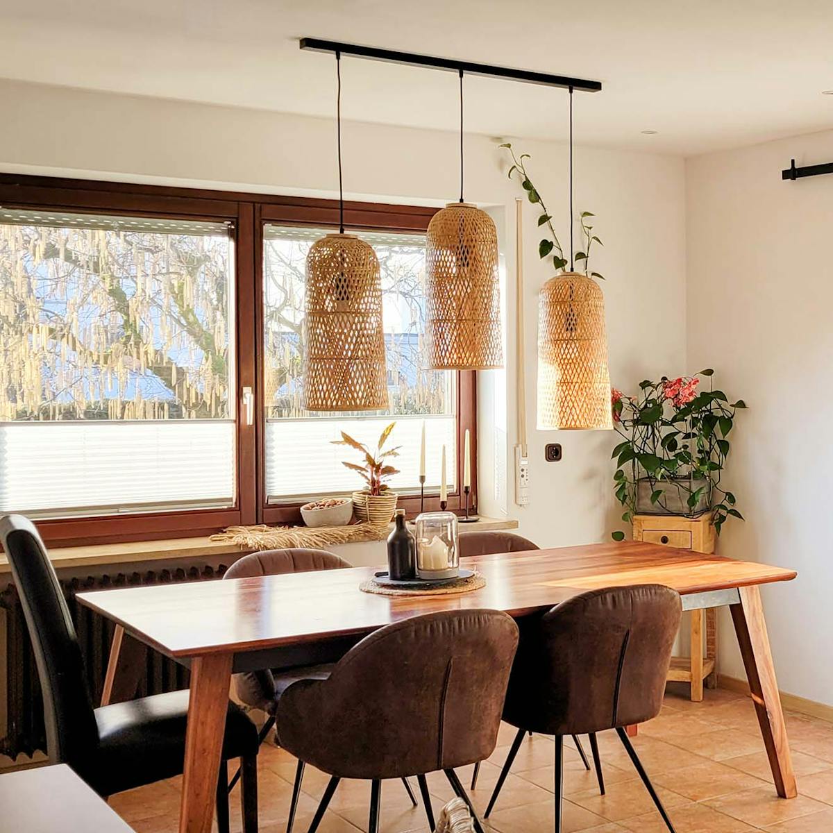rattanowe lampy wiszące nad drewnianym stołem stojącym przy oknie
