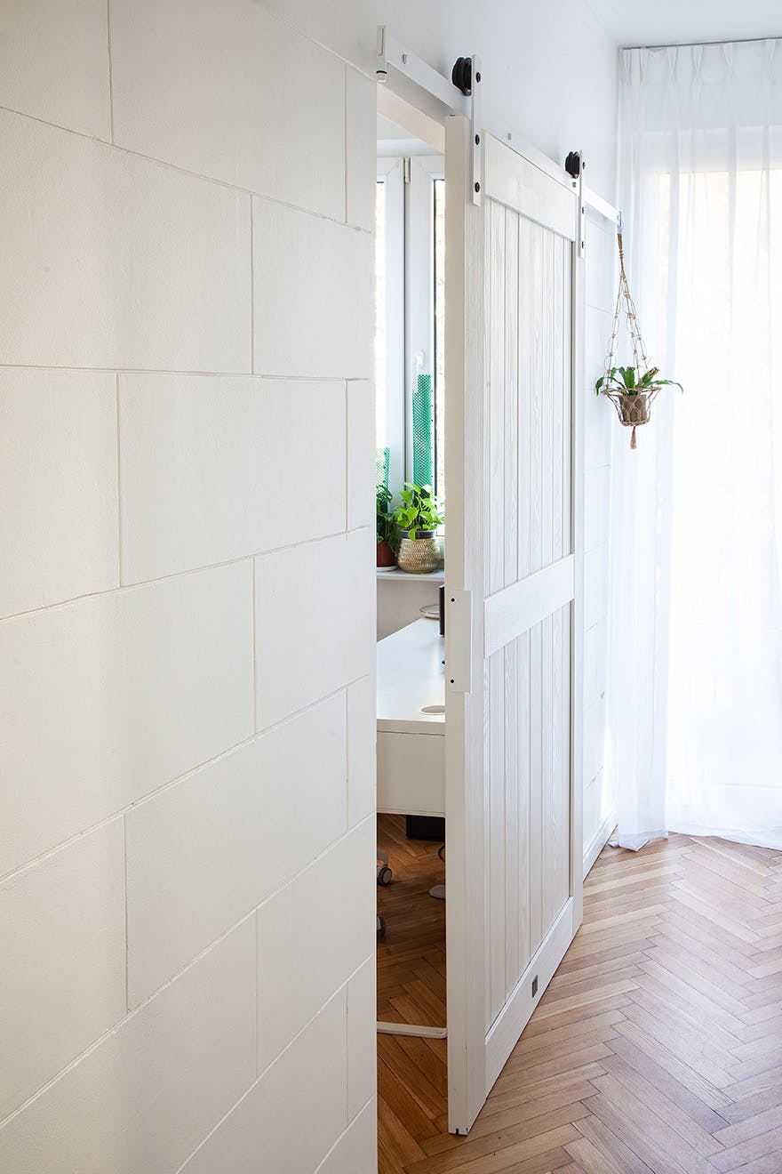 white wooden sliding door in a narrow corridor