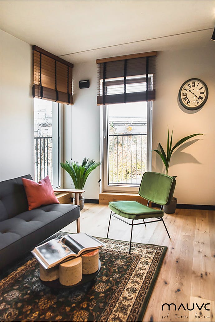 Canapé rétro gris et fauteuil vintage vert dans un petit salon