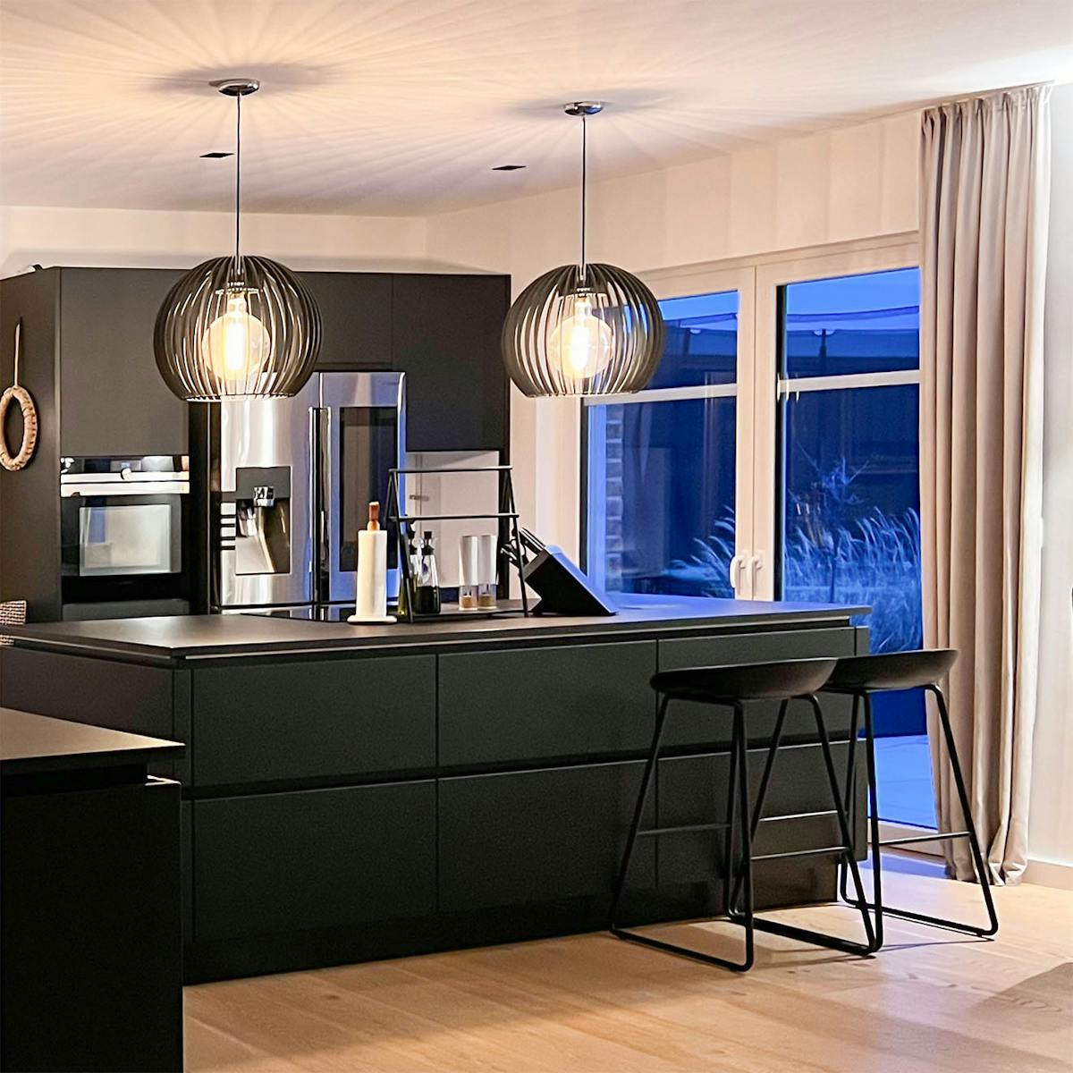 moderne Küche mit schwarzen Möbeln und silbernen Haushaltsgeräten