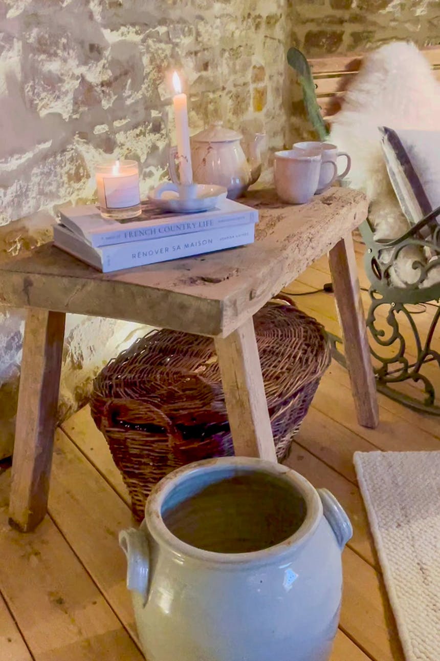 Bücher, Kerzen und Keramikgeschirr auf einem Holzhocker