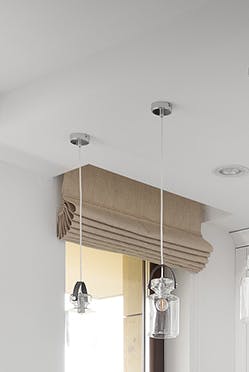 Une kitchenette décorée en blanc avec des accessoires en métal noir