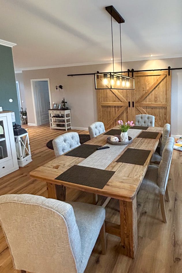 a large wooden table in a dining room decorated in beige and brown colors