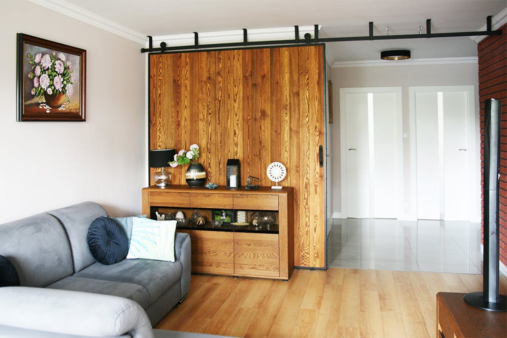 canapé gris et grandes portes coulissantes dans un cadre métallique dans l'agencement du salon