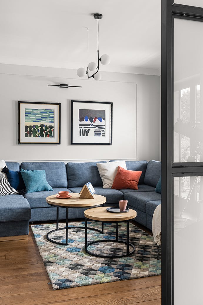 Un grand canapé bleu et un ensemble de tables basses rondes dans le coin salon