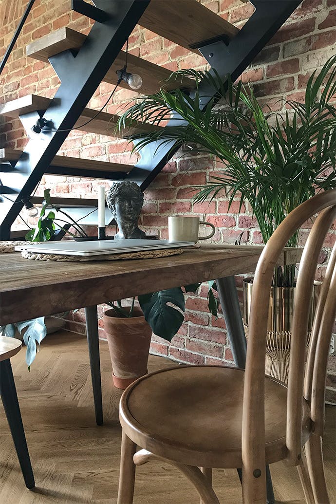 chaises rétro, escaliers en métal dans un style loft, intérieur loft, brique sur le mur, style lofts
