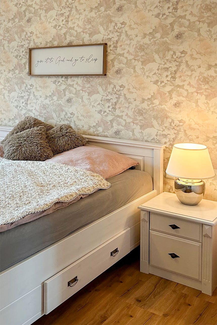 Weiße Möbel, Blumentapete in einem modernen Schlafzimmer im Landhausstil