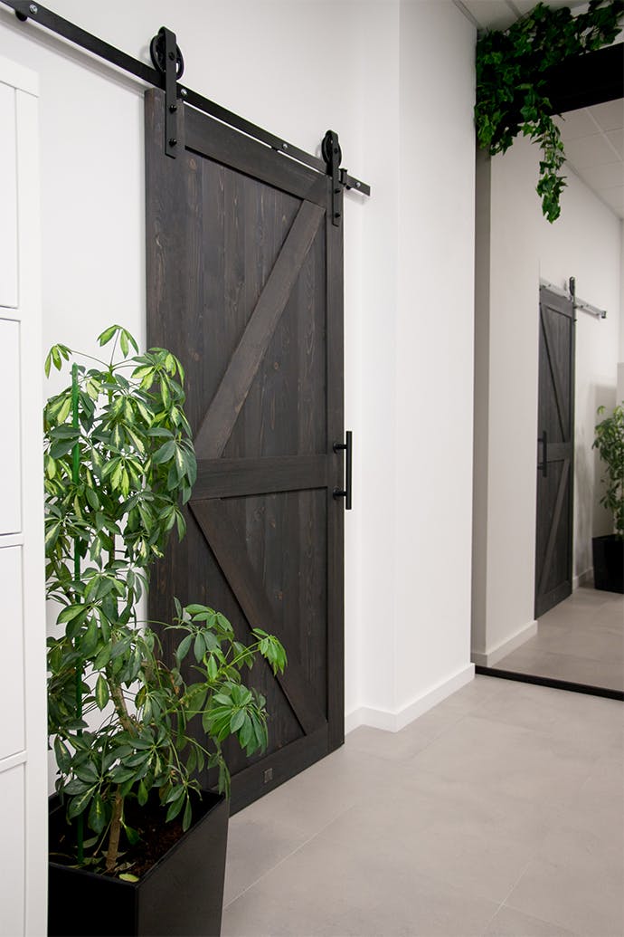 porte coulissante en bois massif noir sur fond de mur blanc