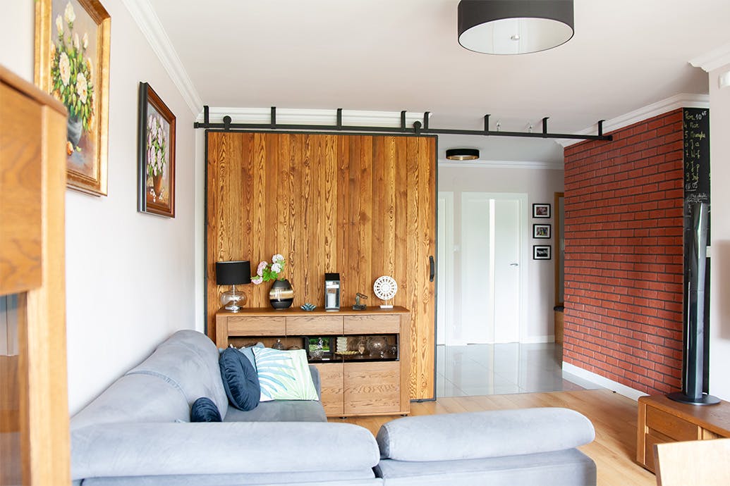 canapé gris et grandes portes coulissantes dans un cadre métallique dans l'agencement du salon