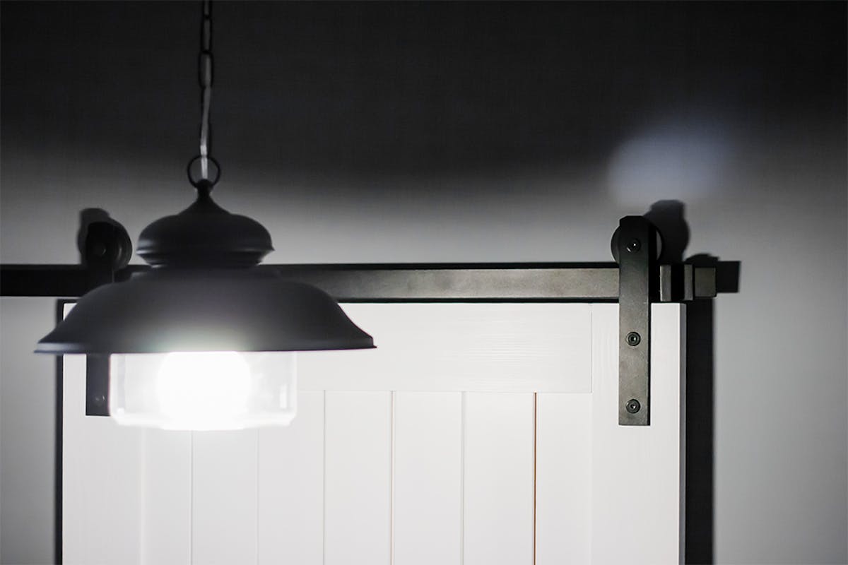 Schiebesystem, weiße Schiebetür, graue Wände in der Halle, schwarze Hängelampe in der Halle, Dekenlampe Schwarz Metall