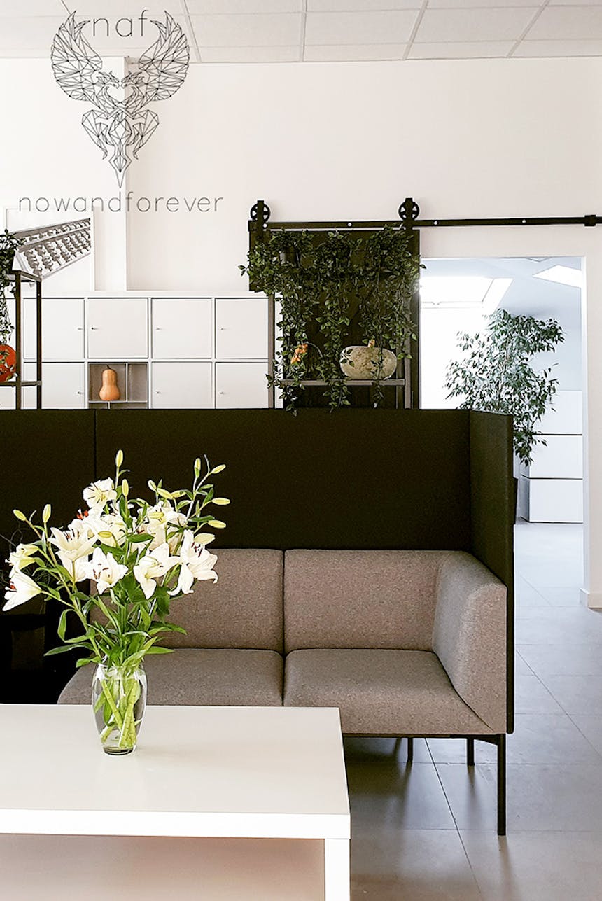 biały stolik kawowy i szara sofa w biurze