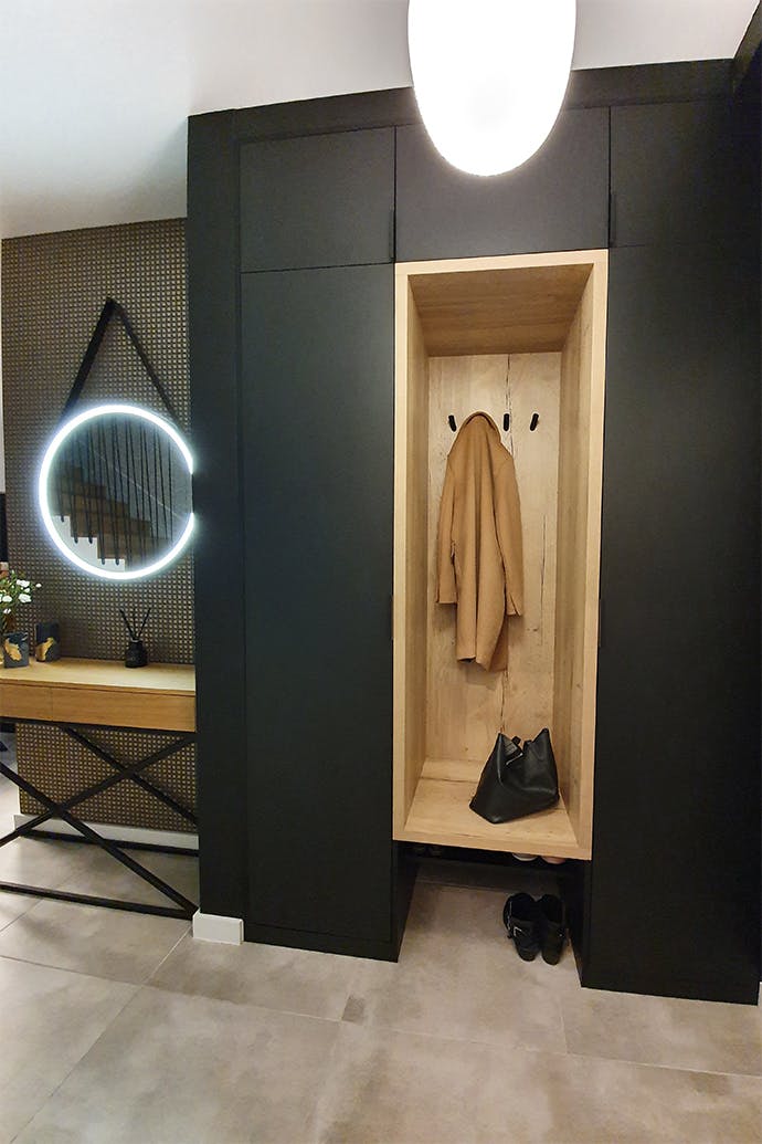 murs noirs dans le hall et un renfoncement en bois pour la garde-robe