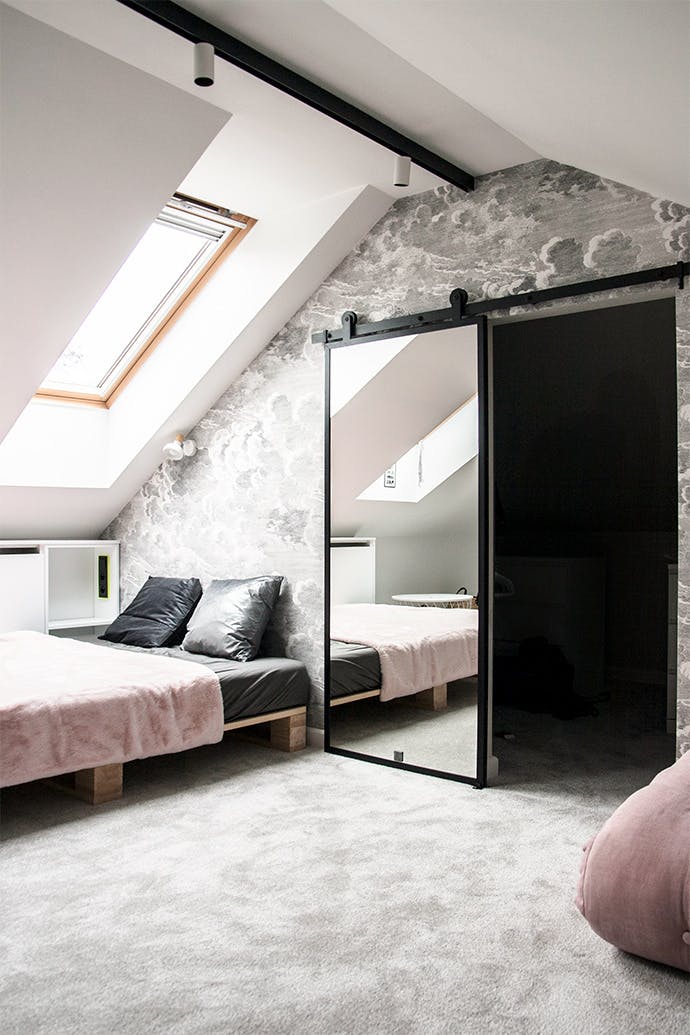 porte ouverte avec miroir à l'armoire dans la chambre mansardée