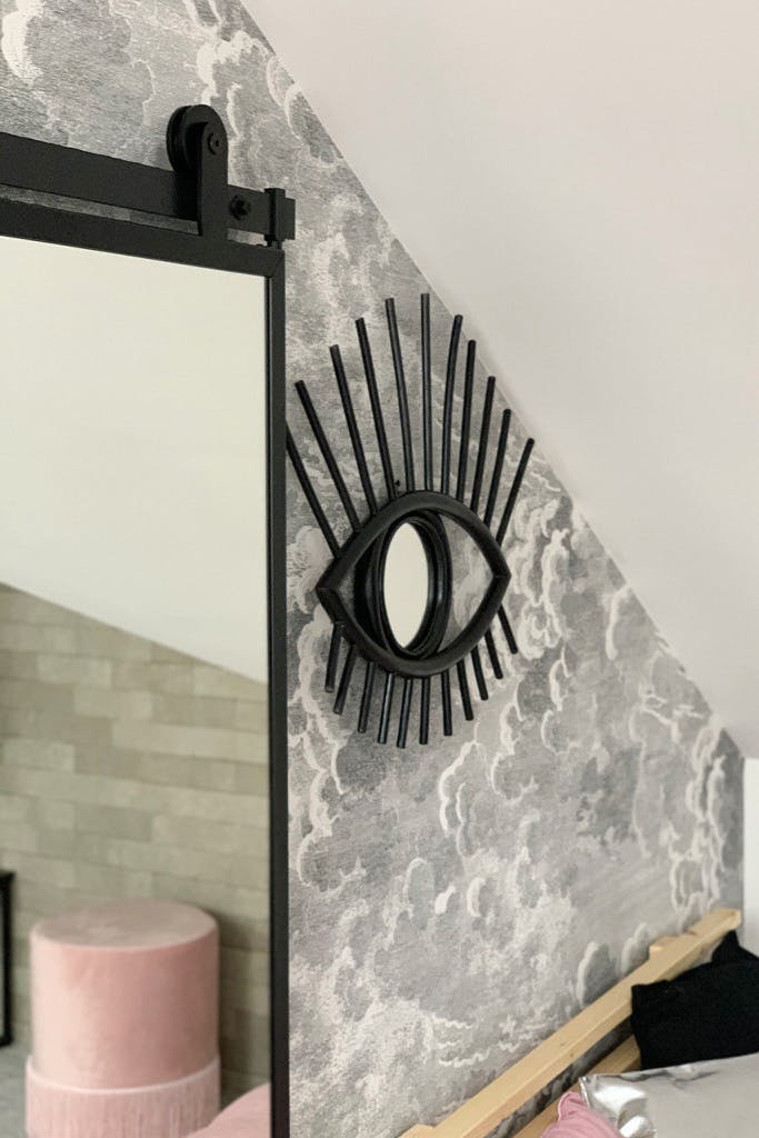 une porte avec un miroir et un miroir décoratif sur le mur gris