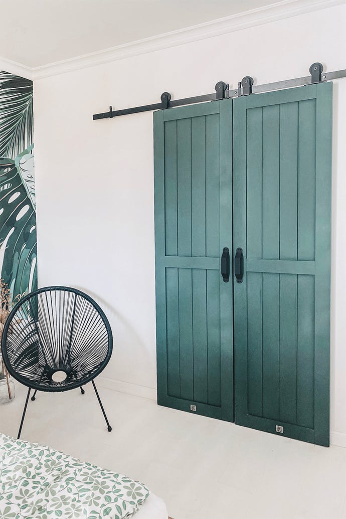 chaise ajourée noire à côté de doubles portes coulissantes vertes