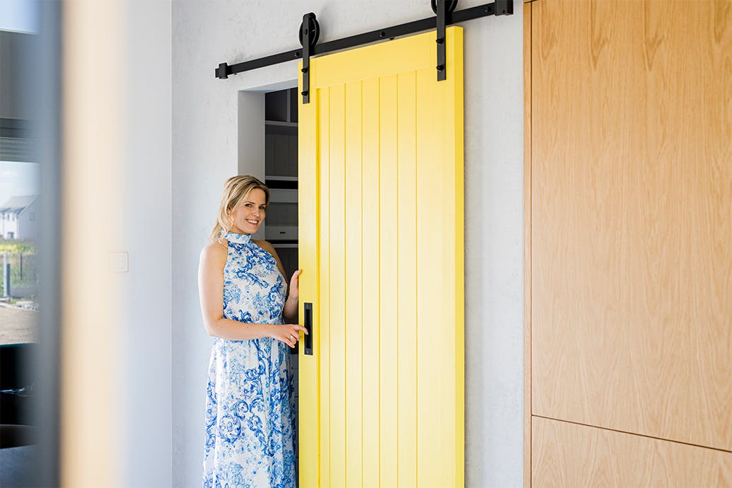 portes coulissantes jaunes fermant un garde-manger dans une cuisine moderne