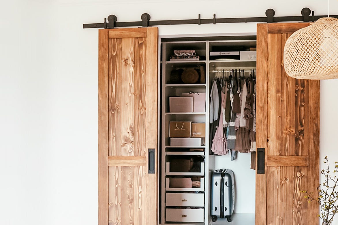 portes coulissantes étroites en bois à double battant fermant l'armoire dans une chambre naturelle