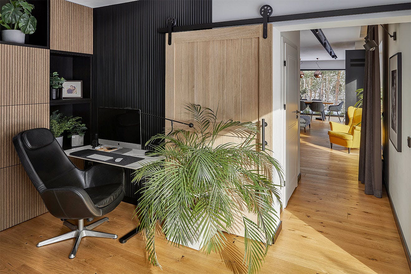 home office with small desk, leather armchair and wooden sliding doors