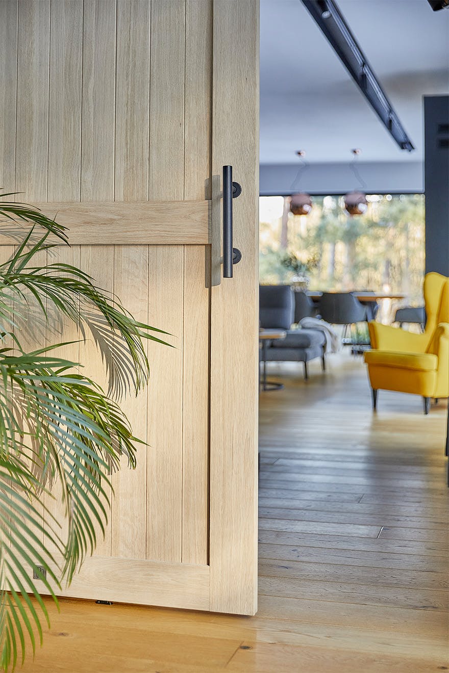 ajar wooden door revealing a fragment of a modern living room