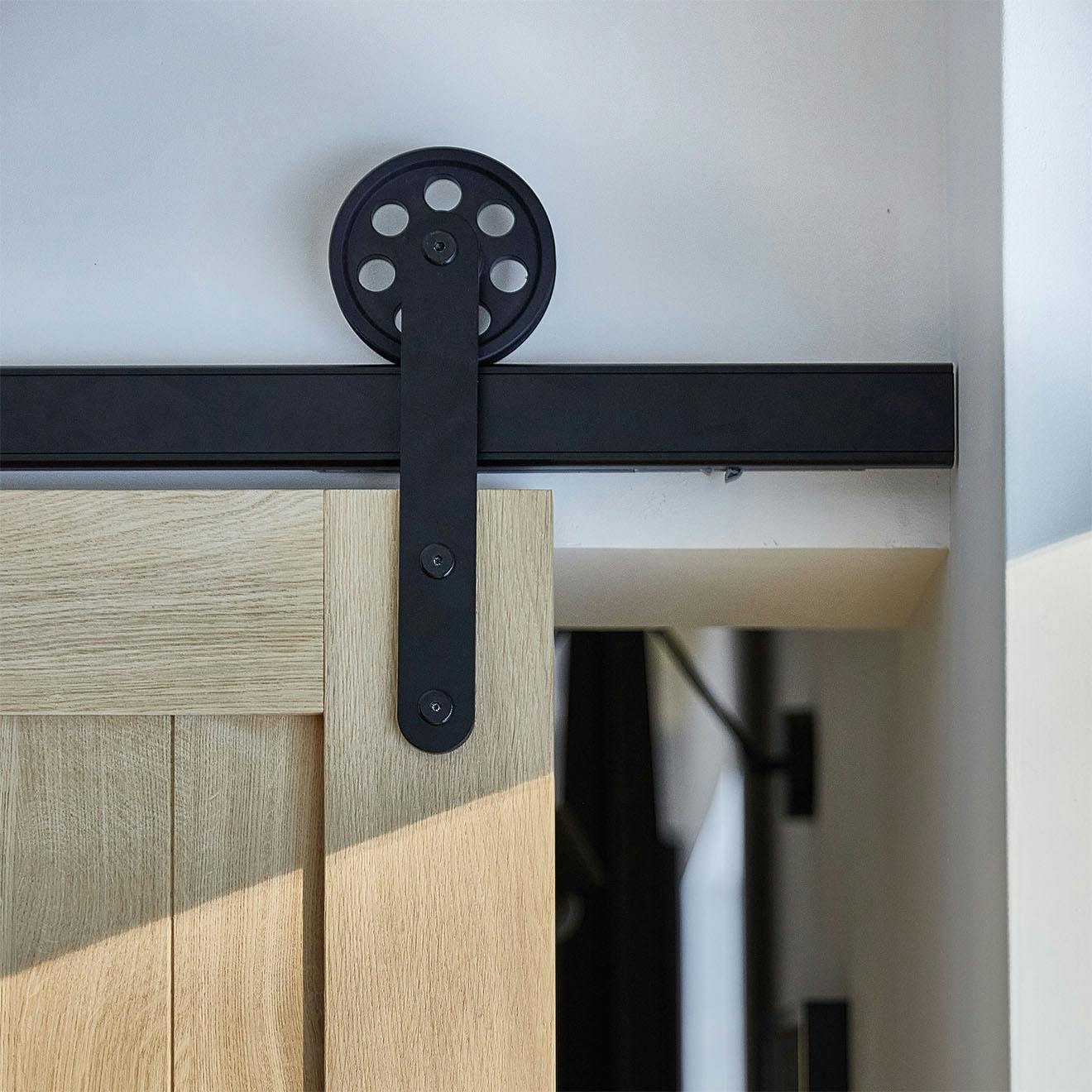 black sliding system with large rollers on wooden doors