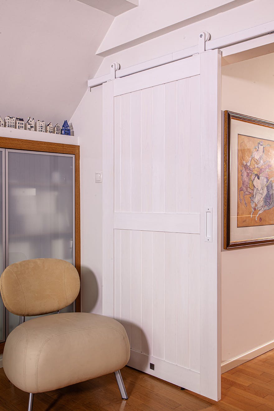beige soft armchair next to white sliding doors