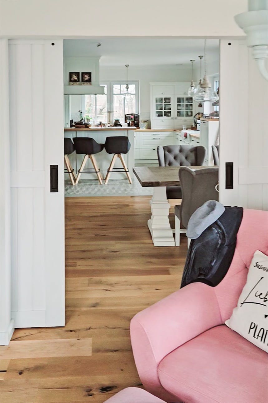 Offene Schiebetüren zeigen einen Teil des Esszimmers und der Küche im rustikalen, modernen Stil