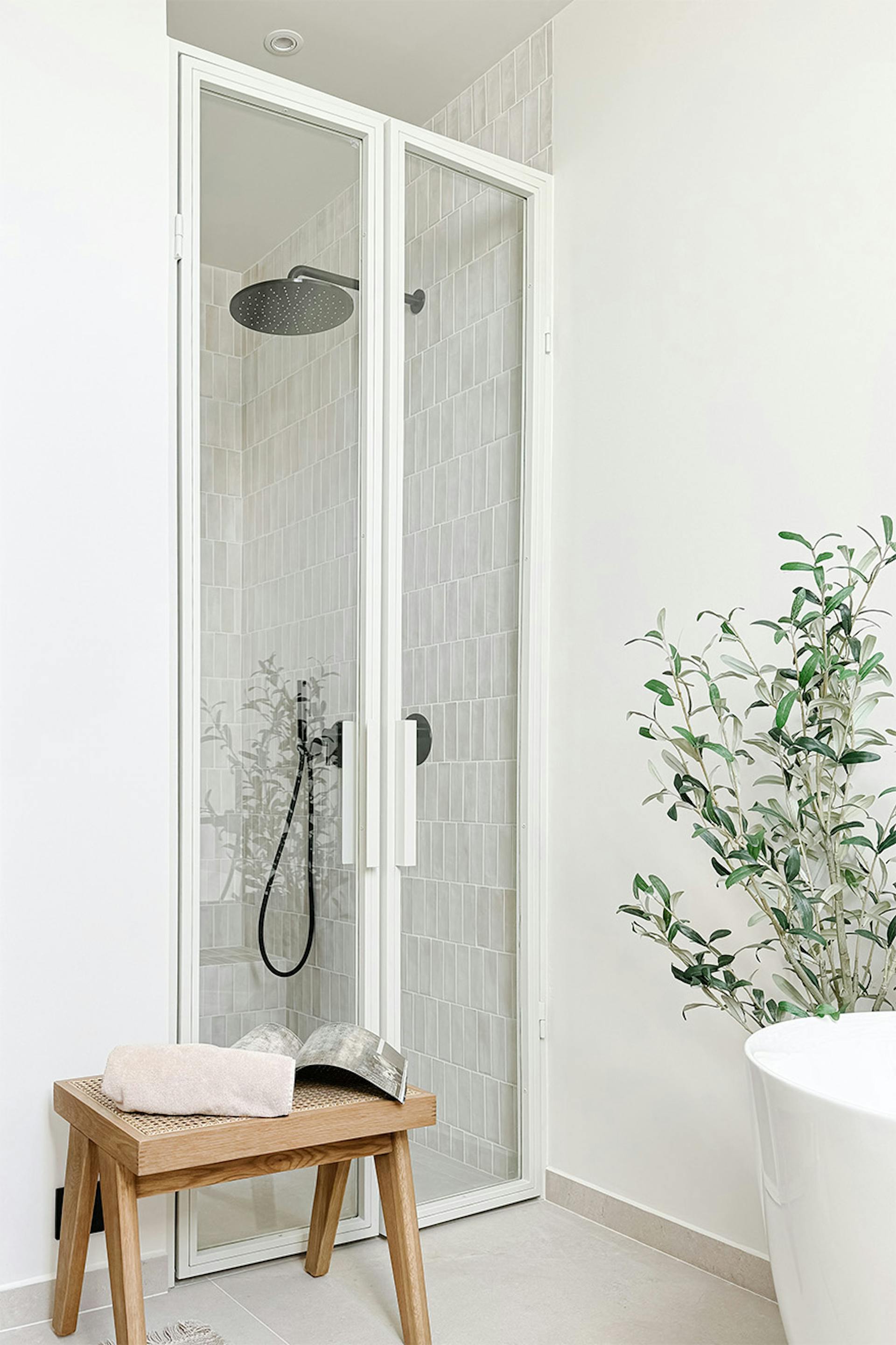 białe szklane drzwi do kabiny prysznicowej znajdującej się we wnęce