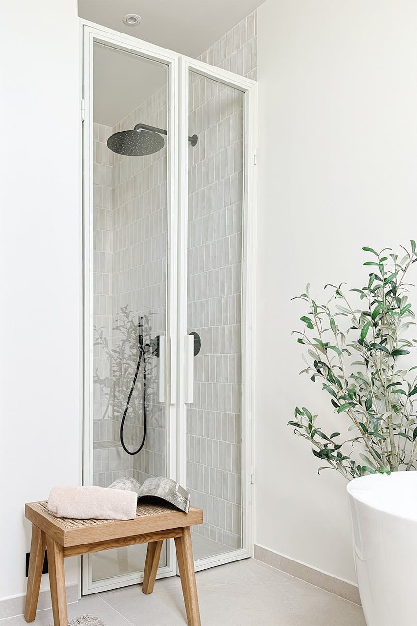 białe szklane drzwi do kabiny prysznicowej znajdującej się we wnęce