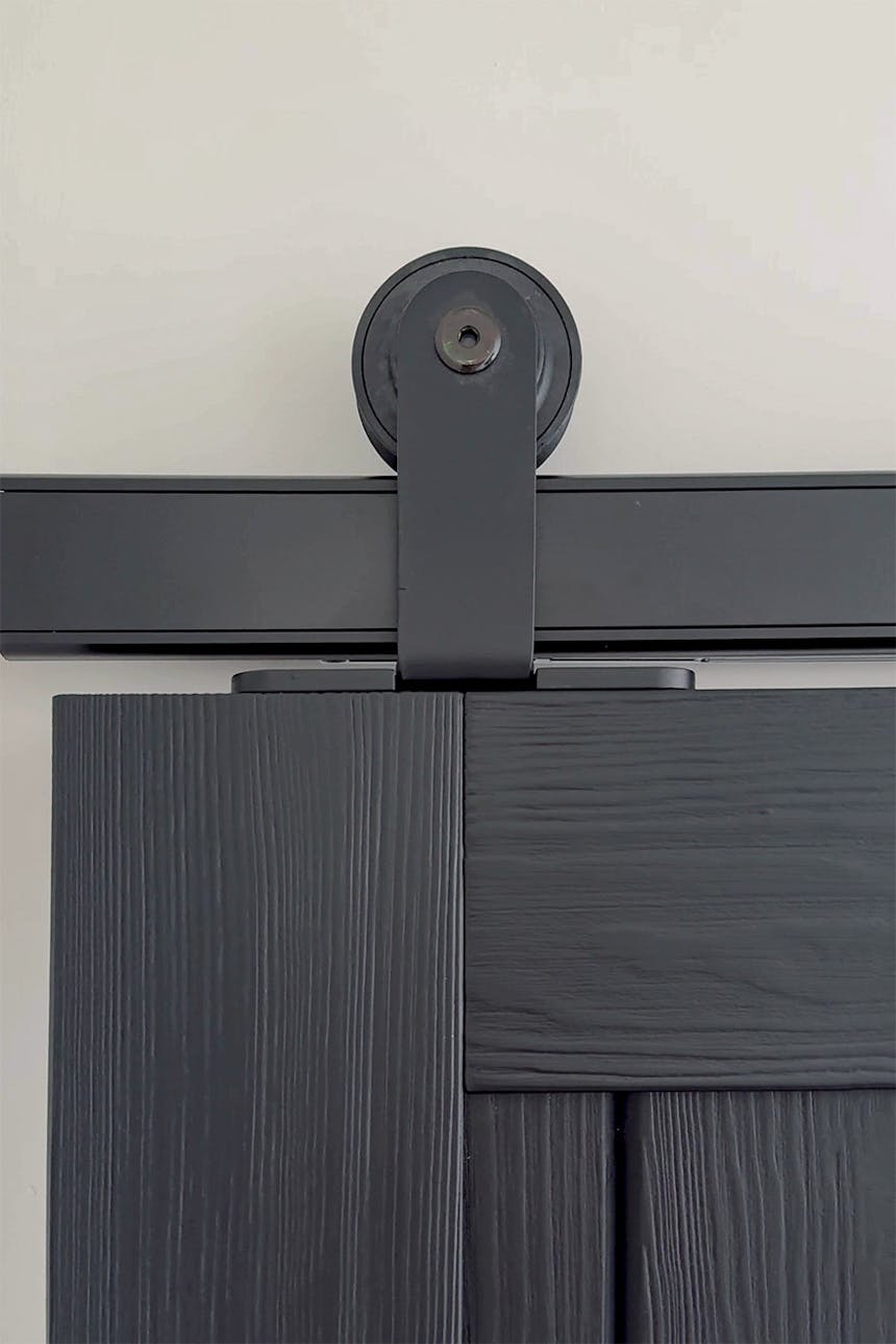 czarny system przesuwny na czarnych drzwiach drewnianych