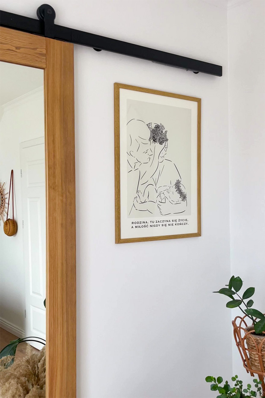 Poster im Holzrahmen an der Wand neben der Holzschiebetür