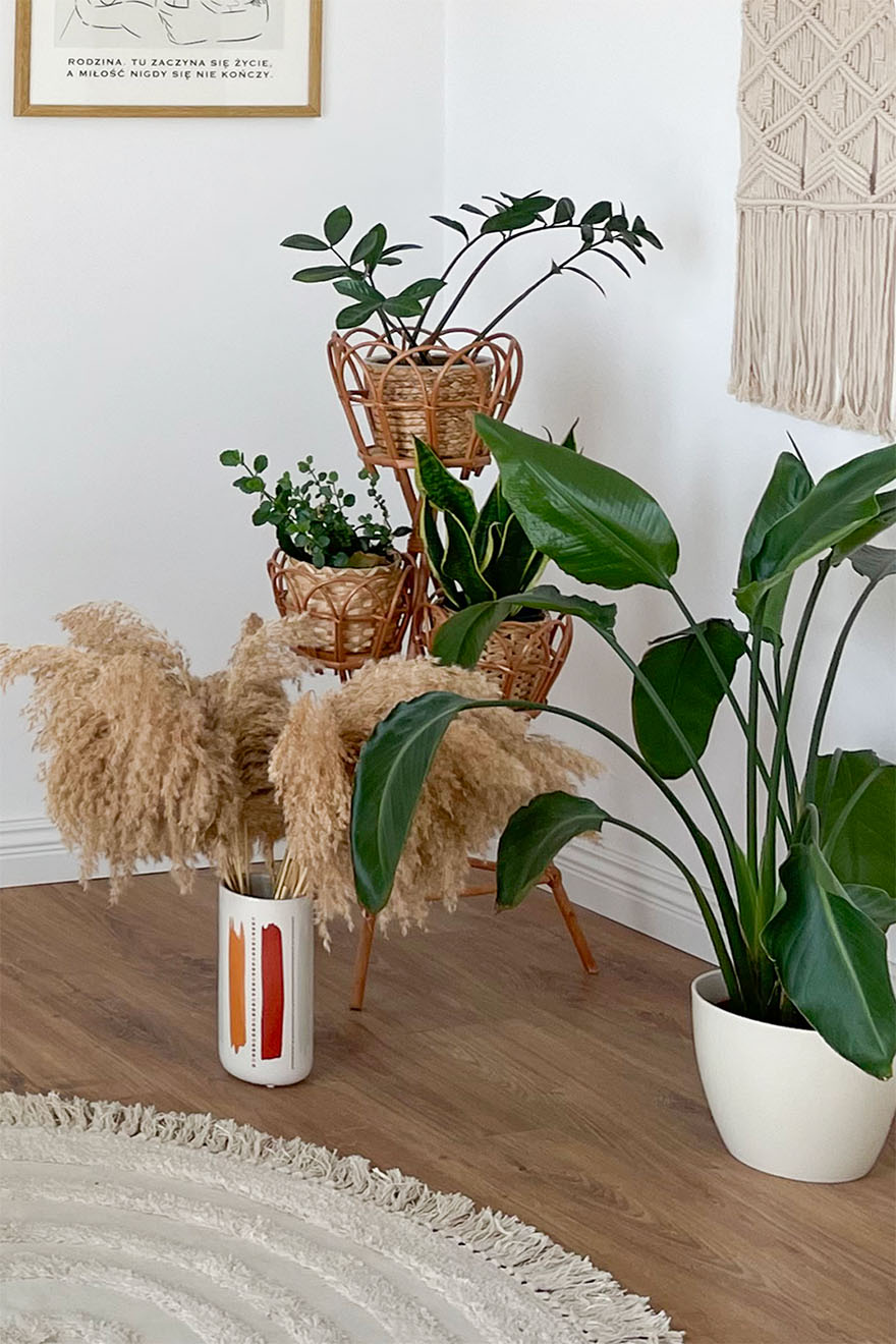 Topfpflanze auf dem Boden neben einem Blumenständer aus Bambus