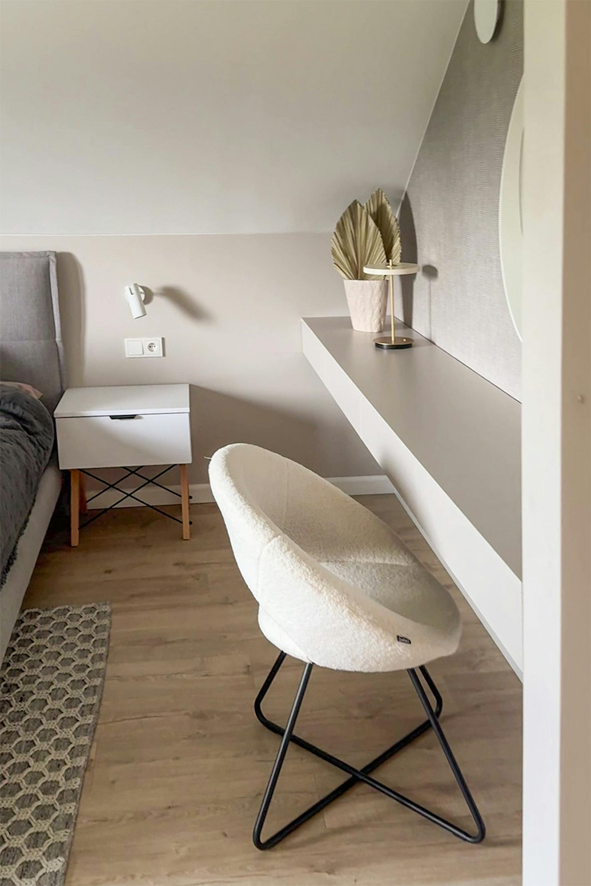 kremowe krzesło tapicerowane przy toaletce w minimalistycznej sypialni