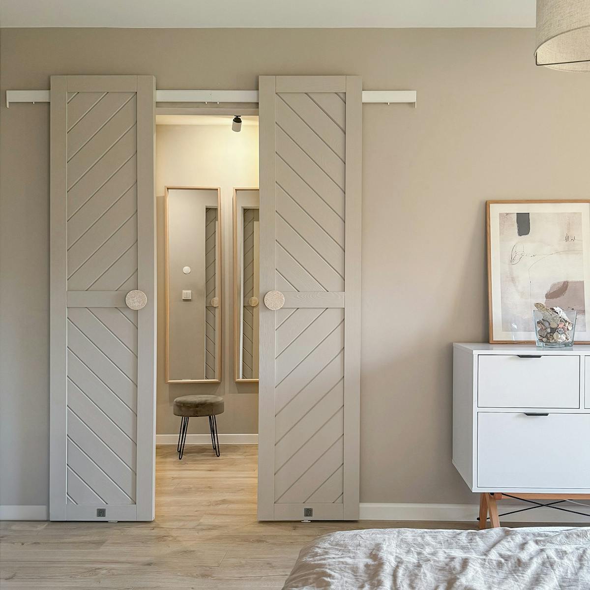 Offene Doppelschiebetüren zum Ankleidezimmer in einem minimalistischen Schlafzimmer