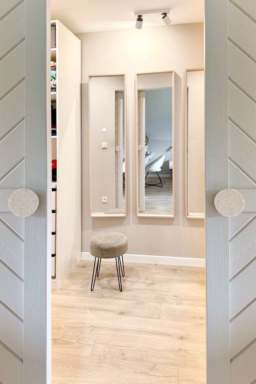 ein Satz von drei langen Spiegeln an der Wand im Ankleidezimmer