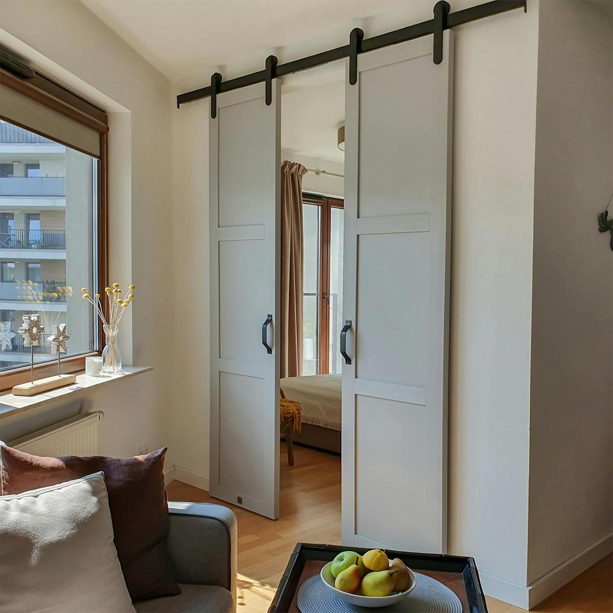 graue Doppelschiebetüren für ein Schlafzimmer in einer kleinen Wohnung