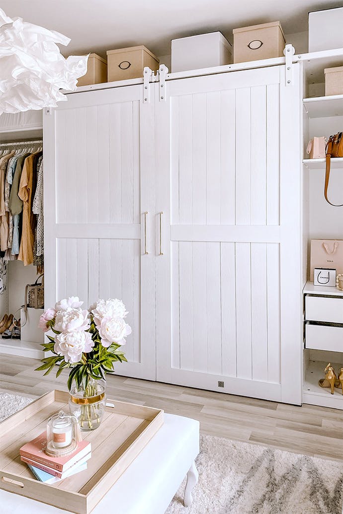 Grandes portes doubles blanches sur un système coulissant blanc dans un agencement de garde-robe