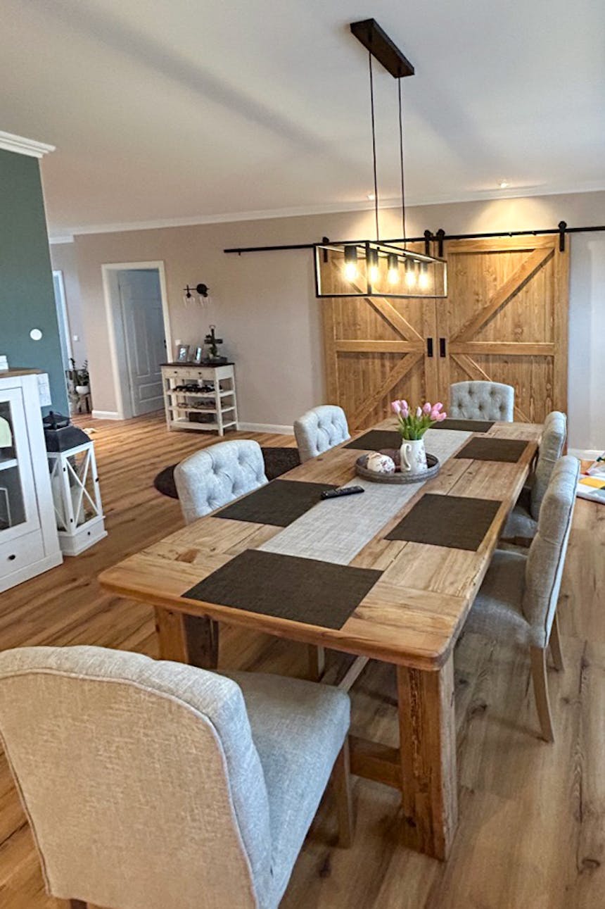 Ein großer Holztisch in einem Esszimmer, das in Beige- und Brauntönen dekoriert ist