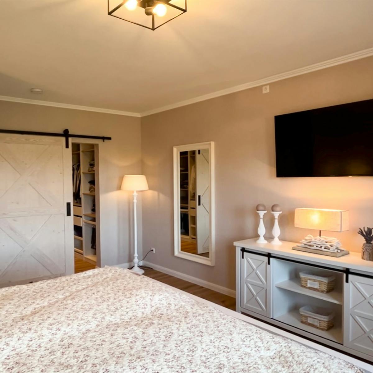 styl modern farmhouse w sypialni z garderobą ukrytą za drzwiami przesuwnymi