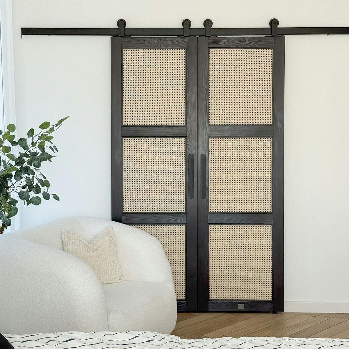 schwarze Schiebetüren mit Rattan-Paneelen, eine Kombination aus traditionellem Material und modernem Design