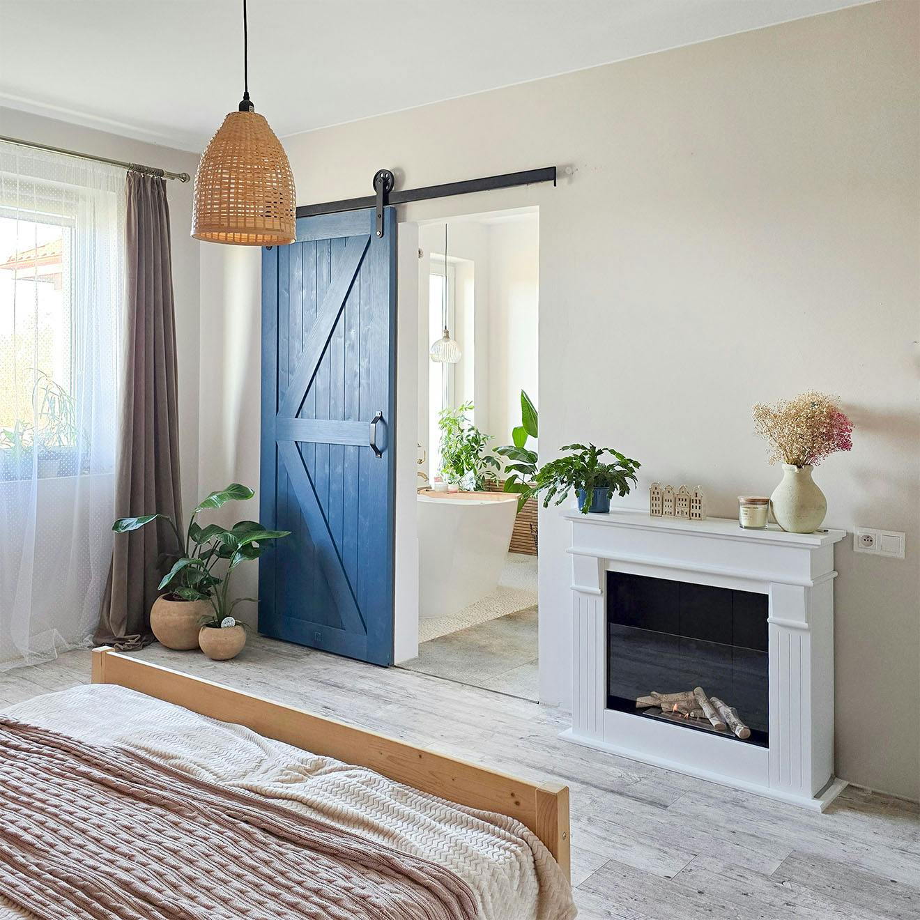 bedroom arrangement with fireplace and blue sliding doors leading to private bathroom
