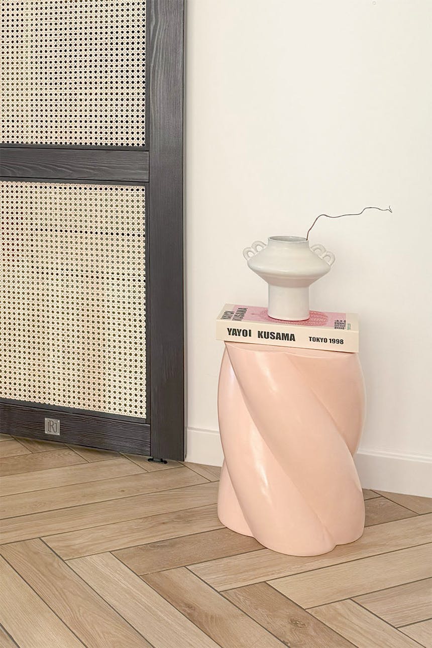 współczesny biały ceramiczny wazon i książka Yayoi Kusama, eksponowane jako elementy dekoracyjne