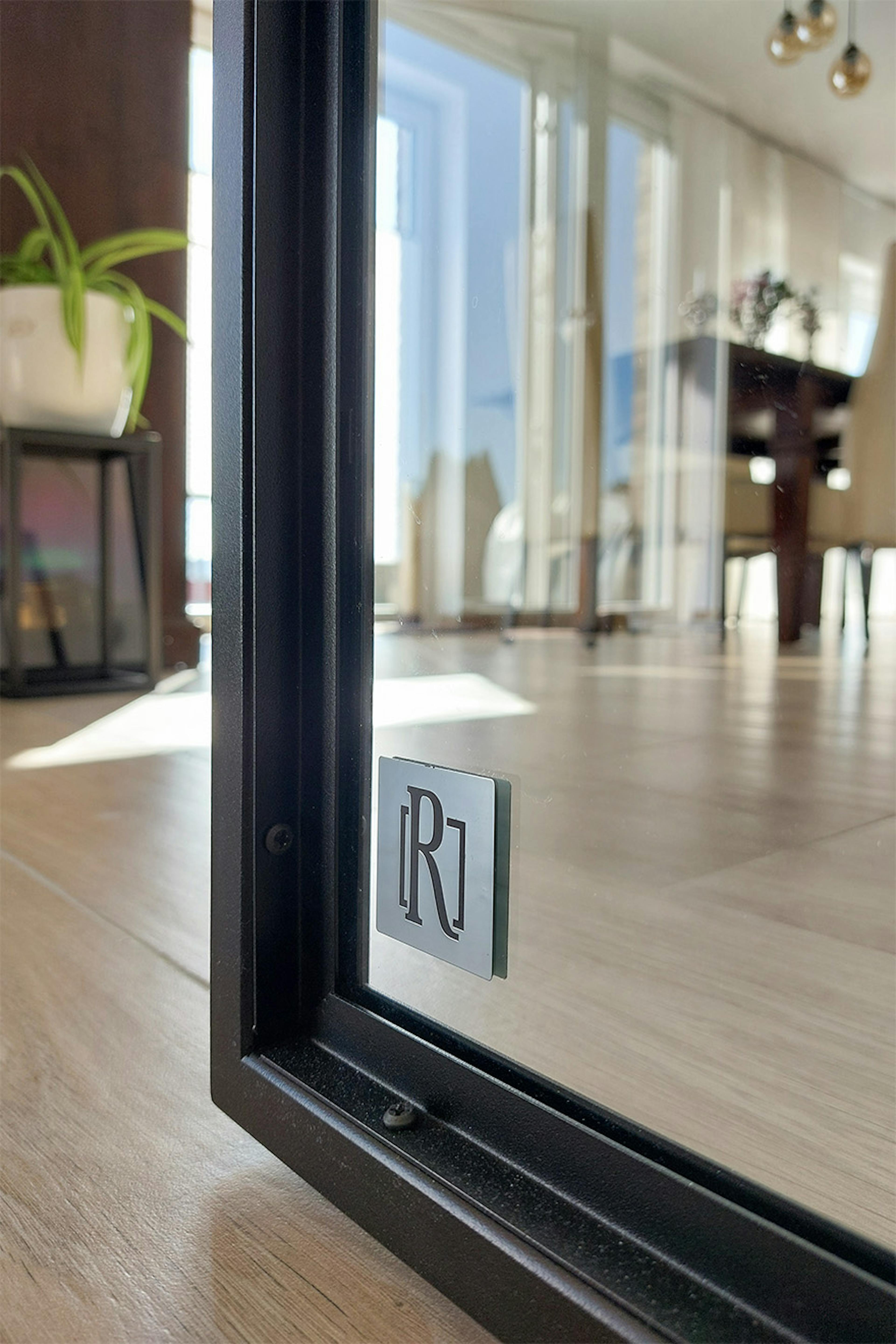 Détail des portes coulissantes en métal noir et verre.