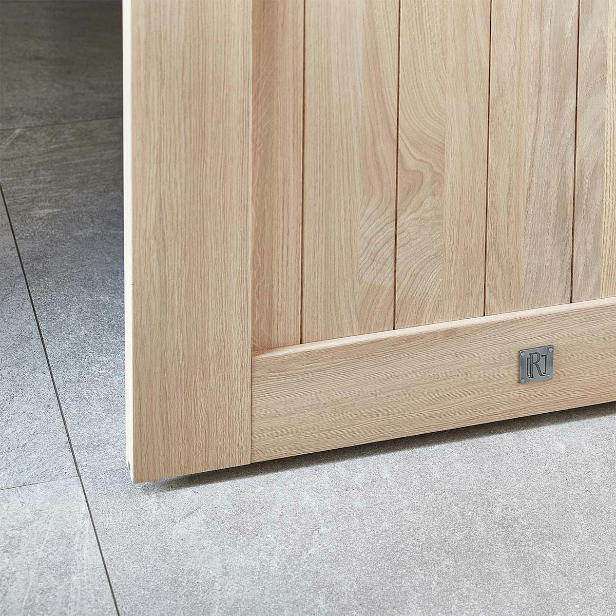 Zbliżenie na dolny róg dębowych drzwi przesuwnych, pokazujące fakturę drewna. Zdjęcie podkreśla wysoką jakość wykonania i naturalne piękno dębu.