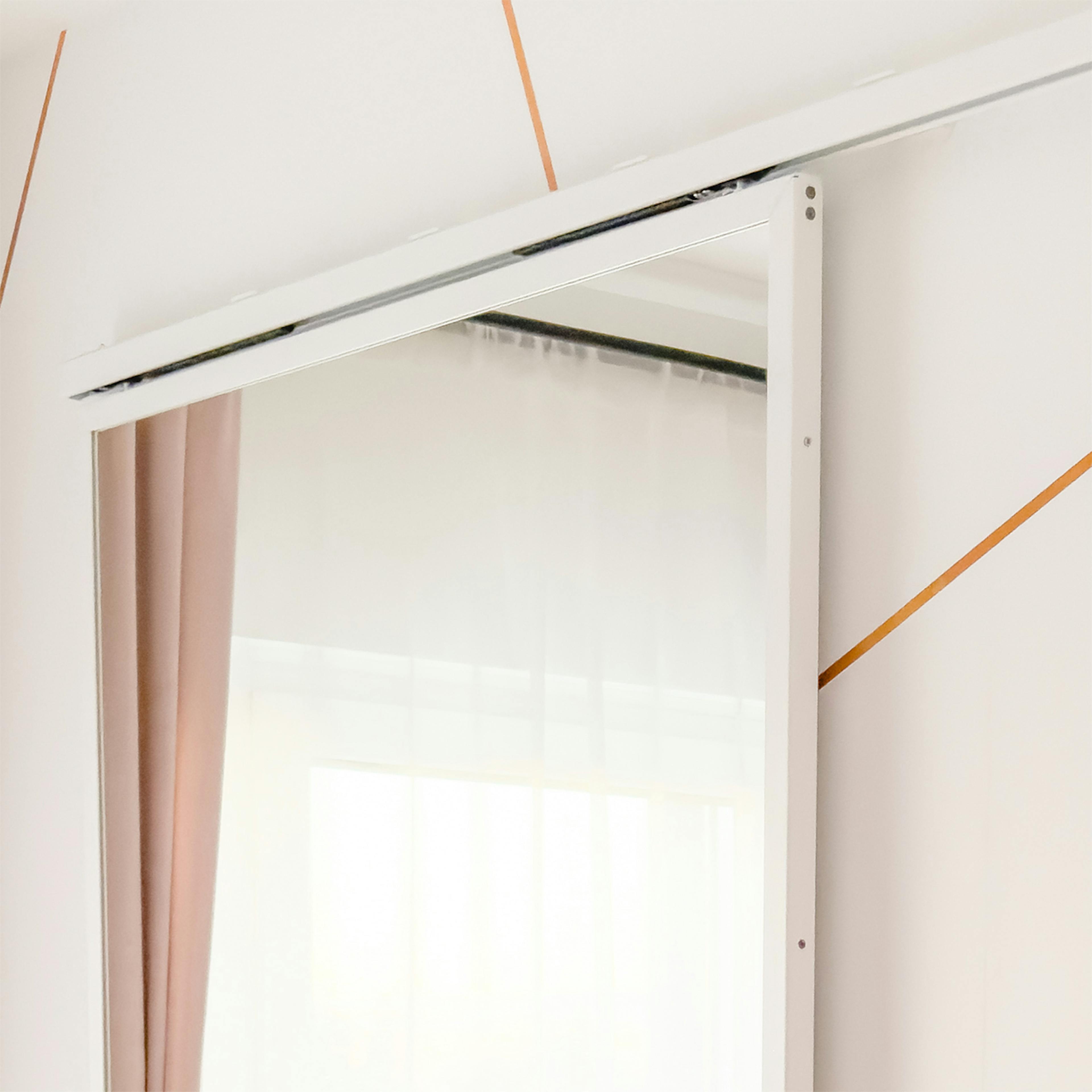 Système coulissant minimaliste blanc et portes miroir pour dressing.