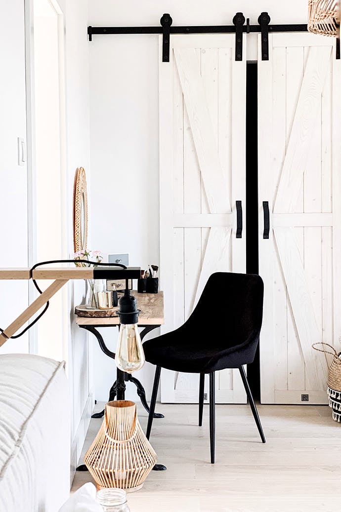 coiffeuse rustique et chaise noire devant des portes coulissantes blanches