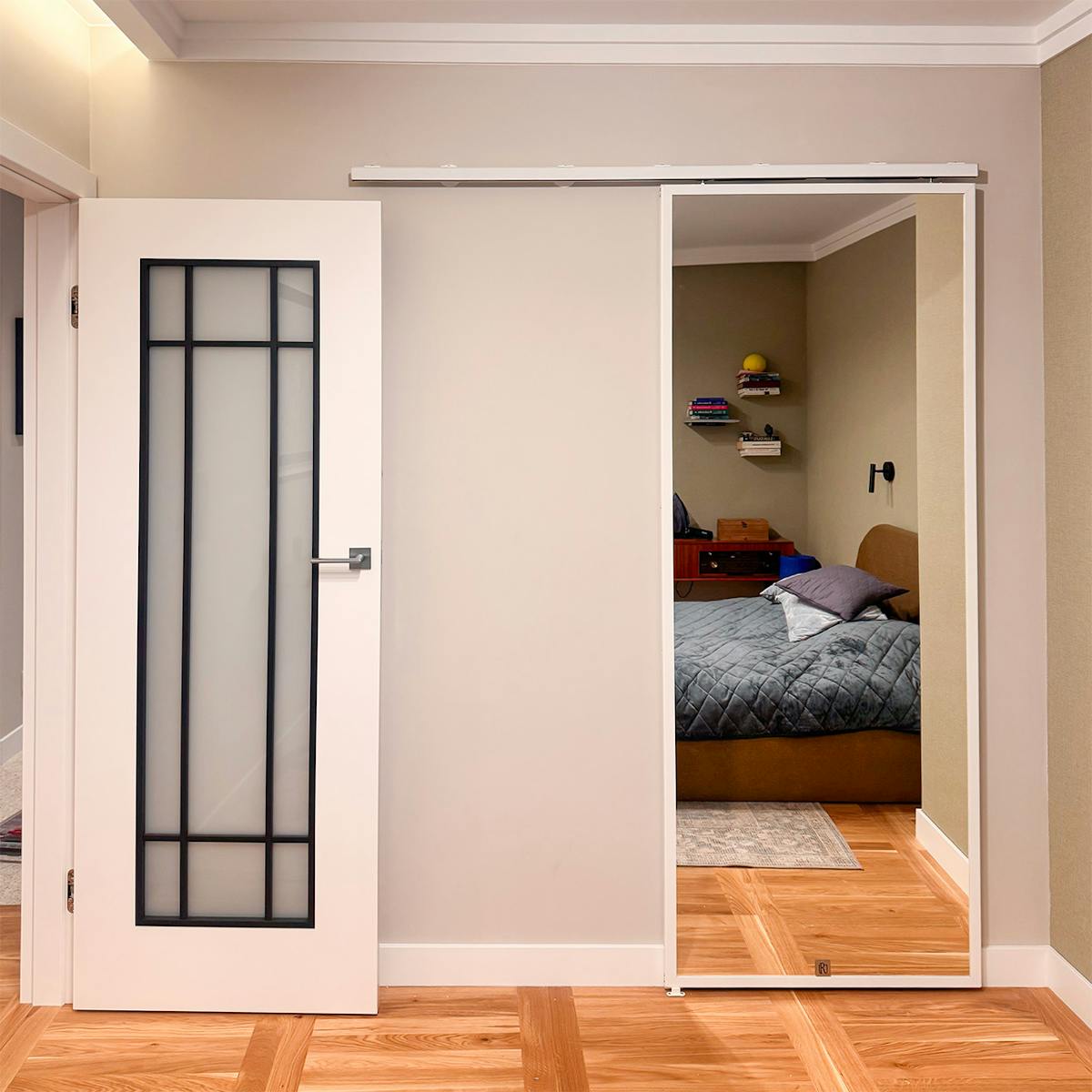 Spiegelschiebetür mit weißem Rahmen auf dem TOP WALL System im Schlafzimmer.