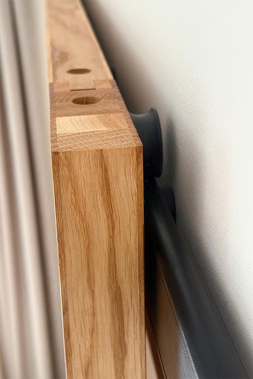 A close-up of a design detail on the oak sliding doors and the minimalist black sliding mechanism.