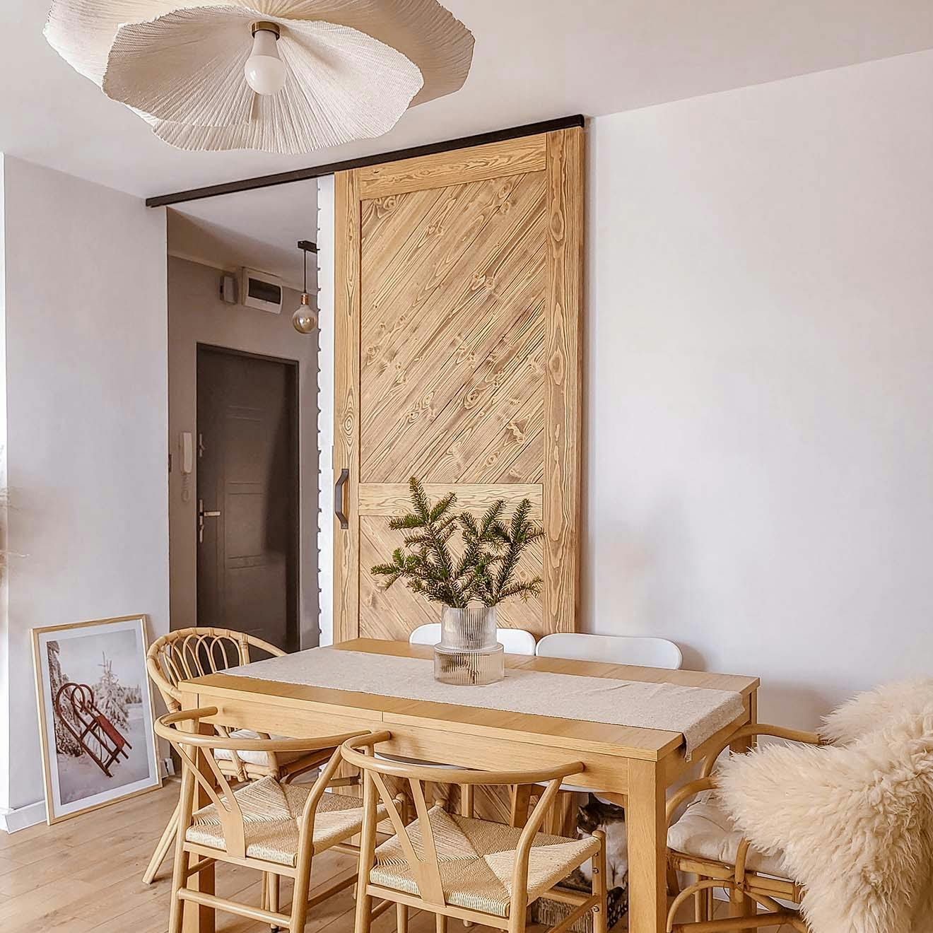 table à manger et portes coulissantes en bois sur fond de mur blanc dans le salon
