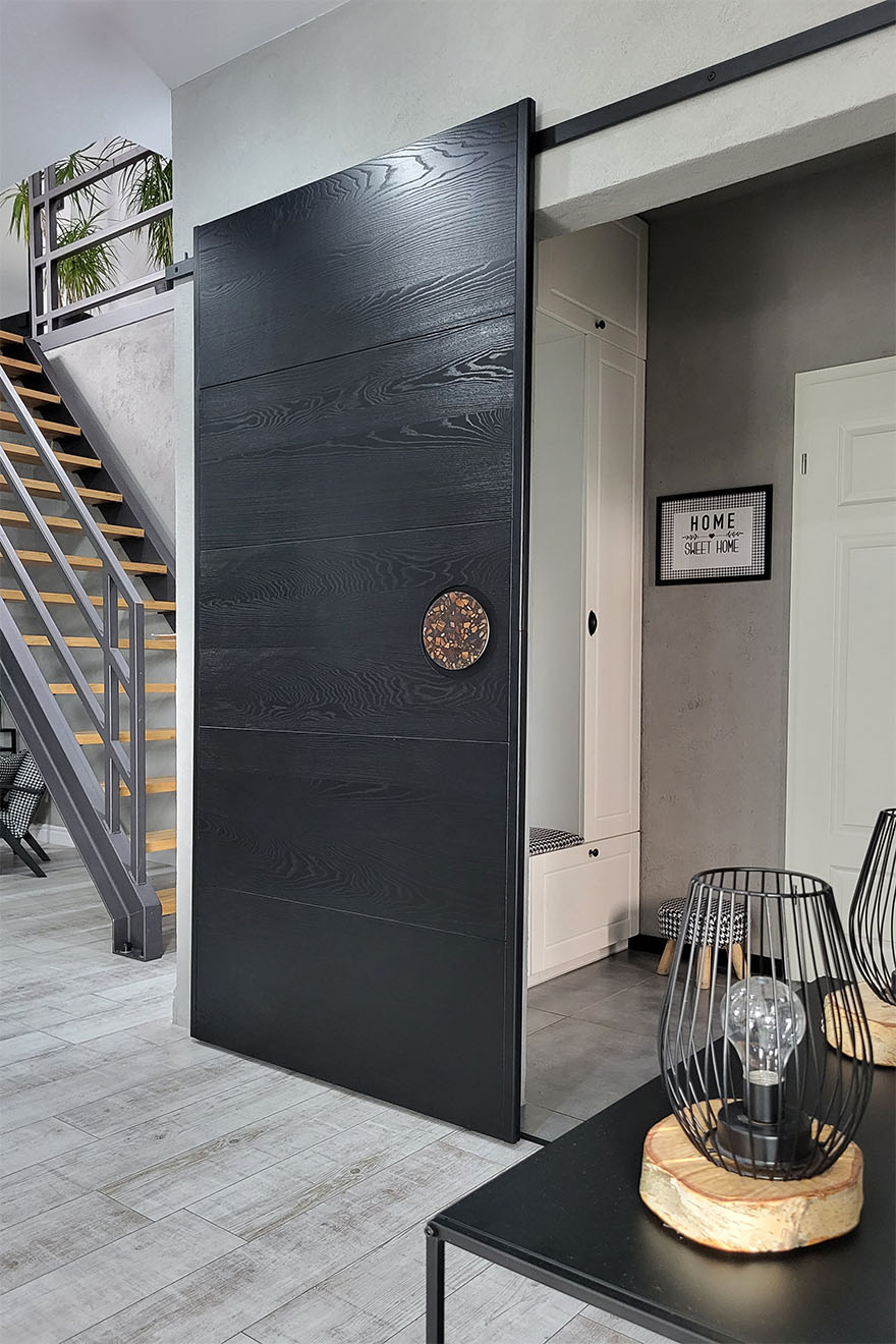 Minimalistische schwarze Schiebetür mit Designergriff in der Halle eines modernen Hauses